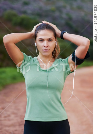 Fitness, portrait and woman tired on run and breathing to rest with music in headphones in exercise or workout. Athlete, break and girl training in summer with resilience for challenge in countryside Fitness, portrait and woman tired on run and breathing to rest with music in headphones in exercise or workout. Athlete, break and girl training in summer with resilience for challenge in countryside 141974839