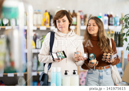 Store visitor women purchases in household chemicals department, choose eye shadow pallet 141975615