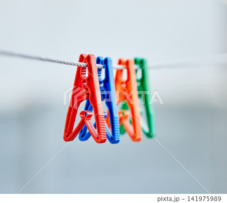 Plastic pegs, collection and outdoor for after washing to balance, holding and dry laundry. Domestic, chores and clothes pin with different colors in closeup view, hanging and clip as set or group Plastic pegs, collection and outdoor for after washing to balance, holding and dry laundry. Domestic, chores and clothes pin with different colors in closeup view, hanging and clip as set or group 141975989