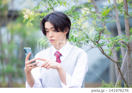 学生　スマホを見ている男子学生　撮影協力：学校法人電波学園東京電子専門学校 141976276