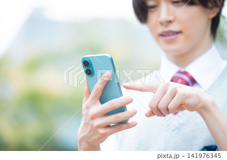 学生　スマホを見ている男子学生の手元　撮影協力：学校法人電波学園東京電子専門学校 141976345