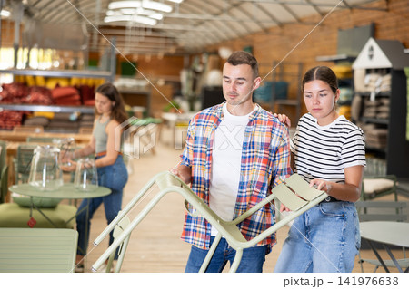 Spouses buyer choose chair in garden furniture store showroom Spouses buyer choose chair in garden furniture store showroom 141976638