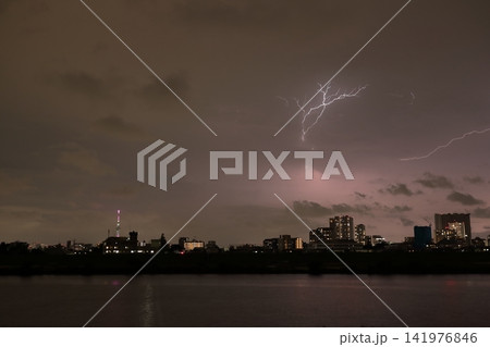 ゲリラ雷雨の雲内放電 雷が照らす都市の夜景 141976846