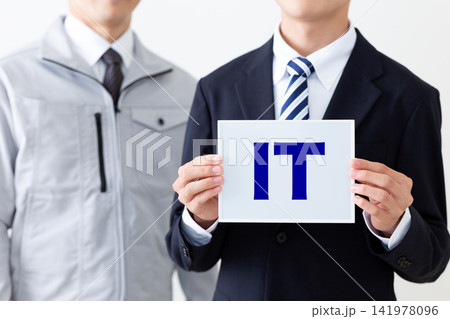ITのホワイトボードを持つスーツを着た若い男性ビジネスマンと作業着のミドル男性 ITのホワイトボードを持つスーツを着た若い男性ビジネスマンと作業着のミドル男性 141978096