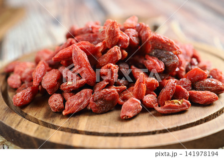 Goji berries on a wooden plate in a kitchen setting 141978194