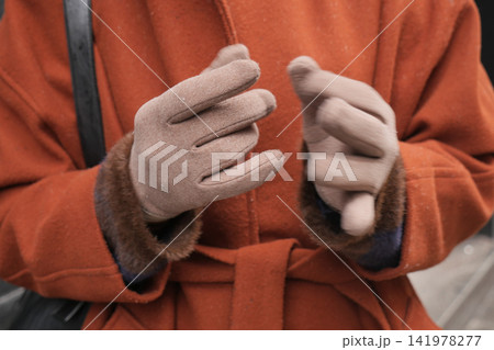 Hands wearing gloves show movement in cold weather Hands wearing gloves show movement in cold weather 141978277