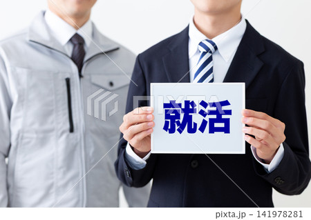 就活のホワイトボードを持つスーツを着た若い男性ビジネスマンと作業着のミドル男性 就活のホワイトボードを持つスーツを着た若い男性ビジネスマンと作業着のミドル男性 141978281