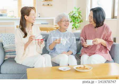 リビングで飲み物を飲みながら会話するミドル日本人女性 141978747