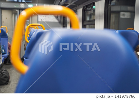 Row Of Blue Seat Backs With Yellow Handrails In Train Carriage Captured With Shallow Depth Of Field Row Of Blue Seat Backs With Yellow Handrails In Train Carriage Captured With Shallow Depth Of Field 141979766