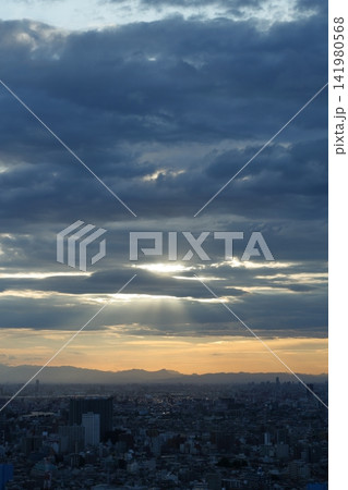 天使の梯子と夕空に浮かぶ山並みと都市風景 天使の梯子と夕空に浮かぶ山並みと都市風景 141980568