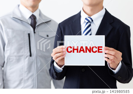 CHANCEのホワイトボードを持つスーツを着た若い男性ビジネスマンと作業着のミドル男性 CHANCEのホワイトボードを持つスーツを着た若い男性ビジネスマンと作業着のミドル男性 141980585
