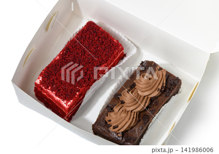 Indulging in a box of delightful desserts featuring rich chocolate and vibrant red velvet cakes 141986006