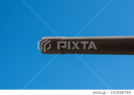 Closeup view of a weathered cannon barrel pointing into clear sky 141986749
