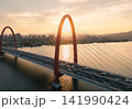 Traffic flows over red bridge as the golden sunset glows off the Qiantang River and the urban skyline. 141990424