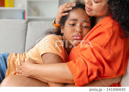 Closeup of black mother comforting sad daughter, hand on girls head, Closeup of black mother comforting sad daughter, hand on girls head, 141990695
