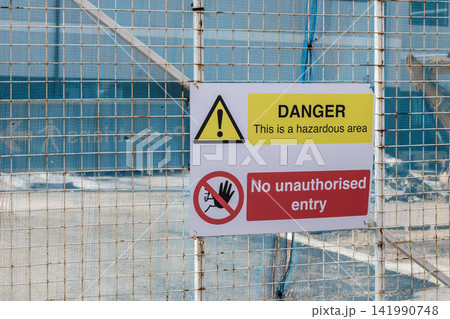 Danger hazard area sign on a security fence Danger hazard area sign on a security fence 141990748
