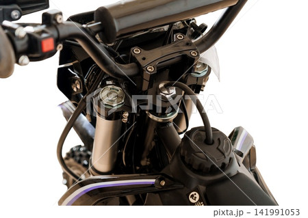 Close up of black dirt bike handlebars and front suspension fork on white background. Close up of black dirt bike handlebars and front suspension fork on white background. 141991053