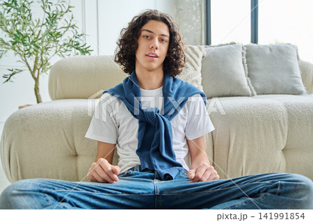 Curly teenage boy student talking and gesturing with hands during video call Curly teenage boy student talking and gesturing with hands during video call 141991854