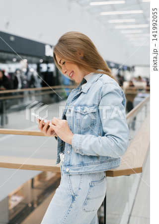 Customer Using Mobile Phone in Fashion Mall Hall Customer Using Mobile Phone in Fashion Mall Hall 141992055