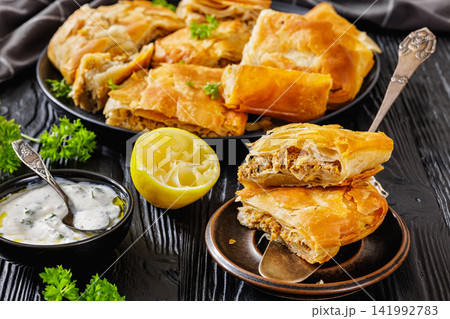 Minced beef pastry slices stacked on a spatula Minced beef pastry slices stacked on a spatula 141992783