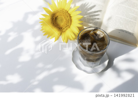 ひまわりと本を添えた夏のアイスコーヒー ひまわりと本を添えた夏のアイスコーヒー 141992821
