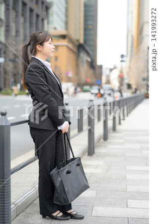 街中で立つ20代日本人女性会社員 街中で立つ20代日本人女性会社員 141993272