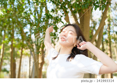 公園で伸びをする日本人女性 公園で伸びをする日本人女性 141993314