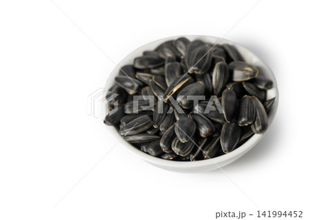 Ceramic Bowl Filled with Black Sunflower Seeds on White Ceramic Bowl Filled with Black Sunflower Seeds on White 141994452