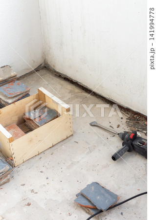 Old floor tiles are being removed from an open apartment balcony Old floor tiles are being removed from an open apartment balcony 141994778