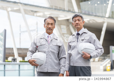 ヘルメットを持つ作業着姿のシニア男性 ヘルメットを持つ作業着姿のシニア男性 141994867