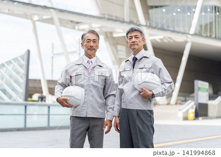 ヘルメットを持つ作業着姿のシニア男性 ヘルメットを持つ作業着姿のシニア男性 141994868