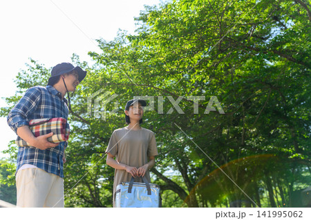 木漏れ日の中、キャンプを楽しむ若い男女 木漏れ日の中、キャンプを楽しむ若い男女 141995062