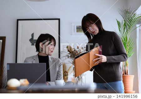 オフィスでノートパソコンを操作する女性と資料を確認する女性 141996156