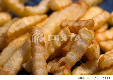 Golden Crinkle Cut Fries Highlighting Texture and Crispiness for Food Photography 141996344