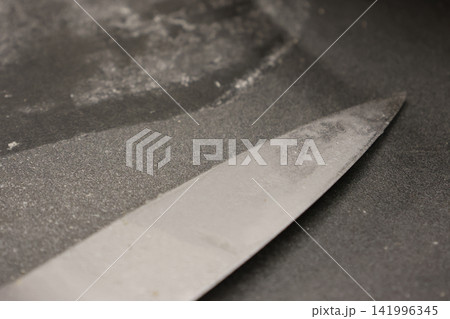 Close-Up of Sharp Kitchen Knife on Gray Countertop for Culinary Themes Close-Up of Sharp Kitchen Knife on Gray Countertop for Culinary Themes 141996345