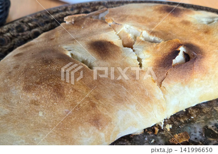 Rustic Baked Flatbread on Decorative Ceramic Plate for Culinary Display Rustic Baked Flatbread on Decorative Ceramic Plate for Culinary Display 141996650