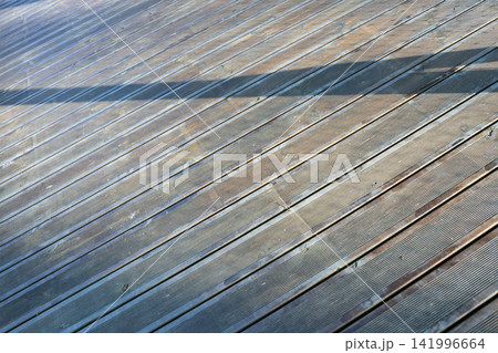 Sunlit Wooden Deck with Shadows - Perfect Background for Summer and Outdoor Themes 141996664