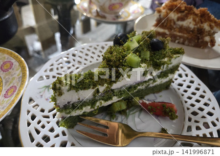Delicious Green Matcha Cake with Fresh Kiwi and Blueberries on Decorative Plate Delicious Green Matcha Cake with Fresh Kiwi and Blueberries on Decorative Plate 141996871