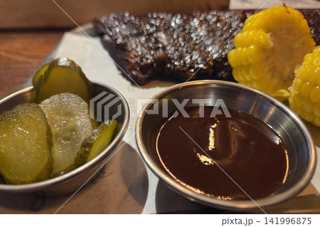Barbecue Feast with Grilled Ribs, Pickles, and Corn - Culinary Inspiration for Food Design Barbecue Feast with Grilled Ribs, Pickles, and Corn - Culinary Inspiration for Food Design 141996875
