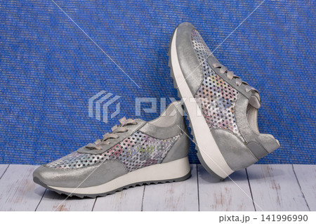Gray Women's sneakers on a blue background Gray Women's sneakers on a blue background 141996990