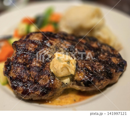Grilled Ribeye Steak with Herb Butter, Mashed Potatoes and Roasted Vegetables on Plate Grilled Ribeye Steak with Herb Butter, Mashed Potatoes and Roasted Vegetables on Plate 141997121