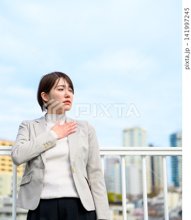 胸に手を当てて考える女性 胸に手を当てて考える女性 141997245
