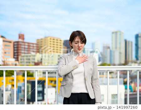 胸に手を当てて不安そうな表情を浮かべるビジネスウーマン 胸に手を当てて不安そうな表情を浮かべるビジネスウーマン 141997260