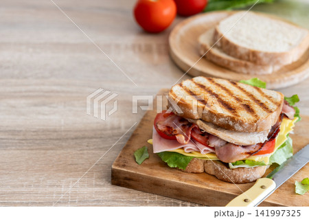 Grilled club sandwich with bacon and ham Grilled club sandwich with bacon and ham 141997325
