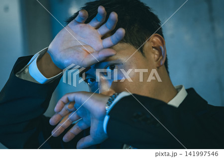 男性が顔の前で手をかざしている すぼかす 141997546