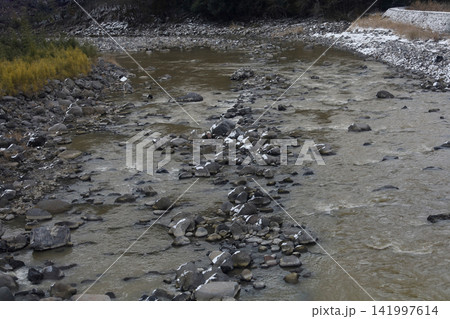 Rocky Mountain River with Snow-Dusted Stones in Winter Japan Rocky Mountain River with Snow-Dusted Stones in Winter Japan 141997614