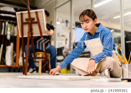 アトリエで床に座り制作する女性 アトリエで床に座り制作する女性 141999361