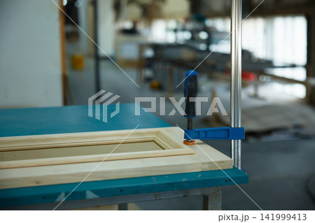 Wooden cabinet door clamped on table Wooden cabinet door clamped on table 141999413