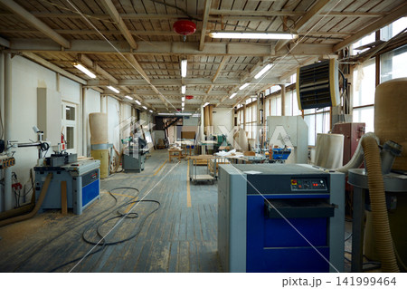 Industrial workshop scene. Abandoned woodworking plant showcasing aged equipment and tools Industrial workshop scene. Abandoned woodworking plant showcasing aged equipment and tools 141999464