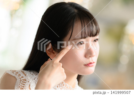 目元を指で確認する女性 目元を指で確認する女性 141999507
